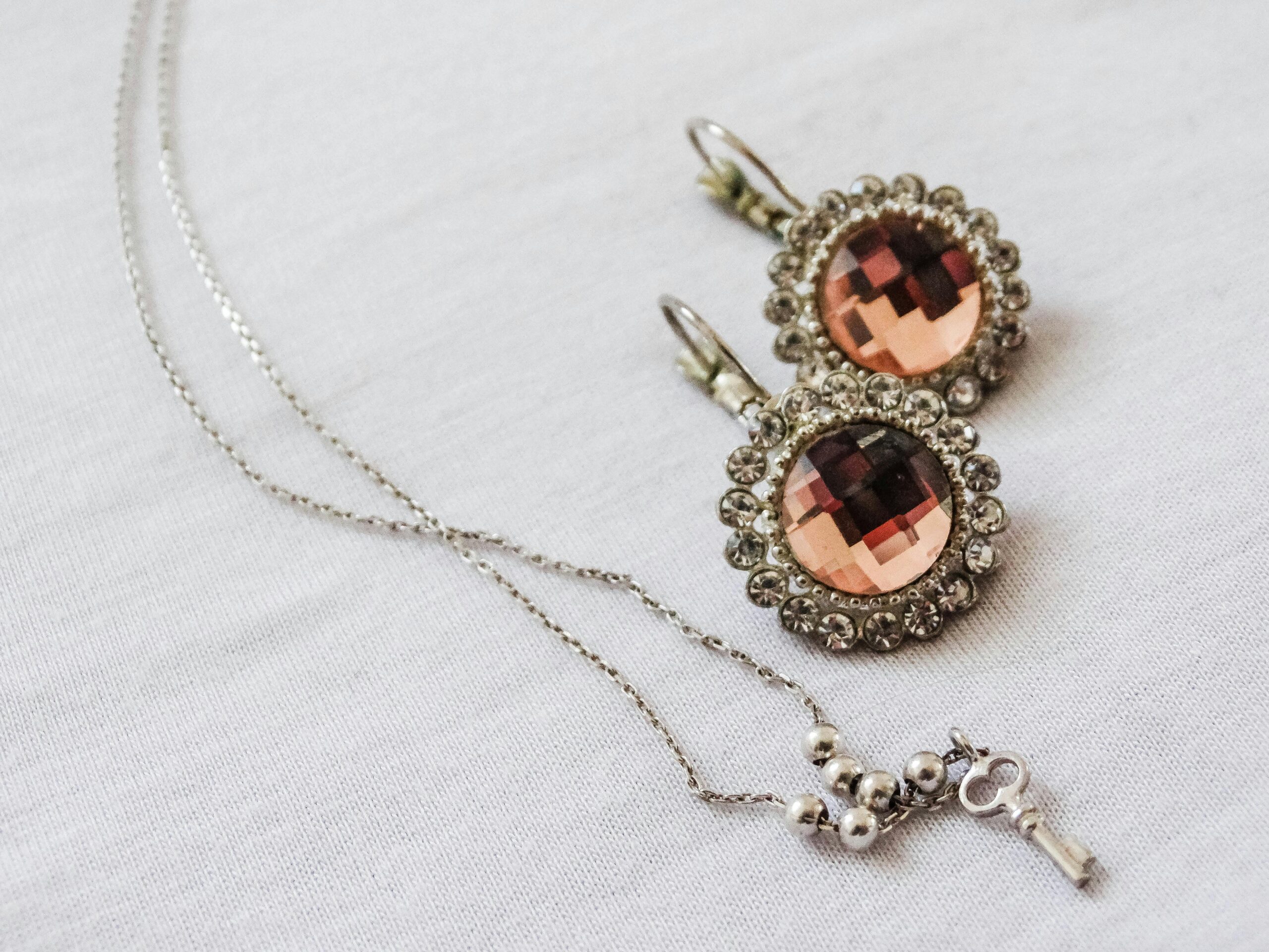 About A close-up view of elegant jewelry featuring sparkling earrings and a delicate necklace, perfect for luxury fashion.